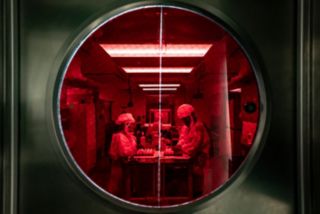 Two women working in a lab  behind a heavy door