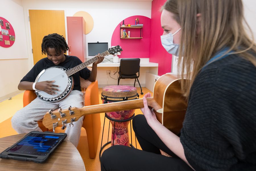 Patient playing banjo with music therapist who is playing guitar