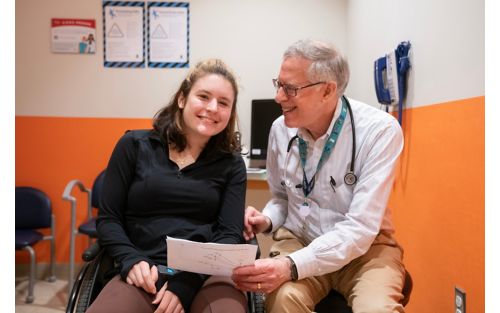 An image of a patient and a doctor looking over paperwork