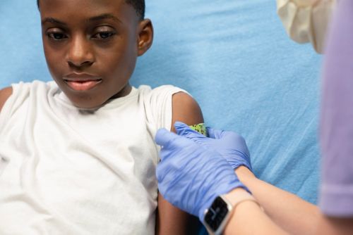 Child gets bandaid put on arm by nurse