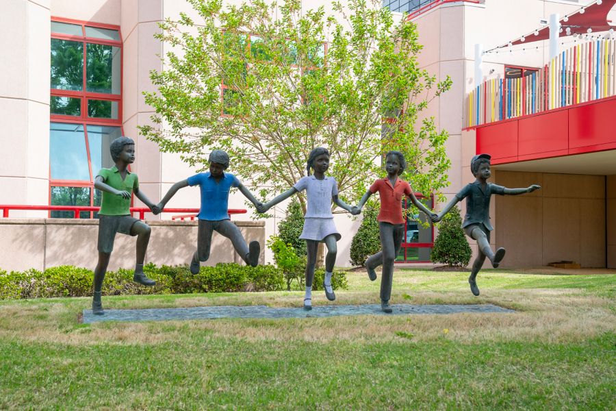 An image of a statue featuring children holding hands and skipping together