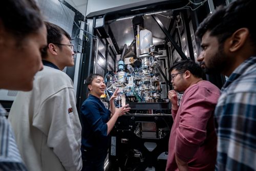 A woman shows a machine to four men