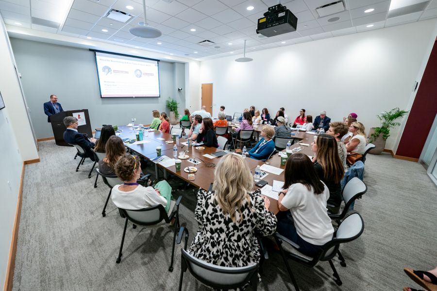 Group of people in conference room watching projection screen