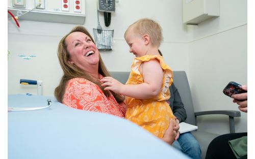 Woman smiling while holding toddler