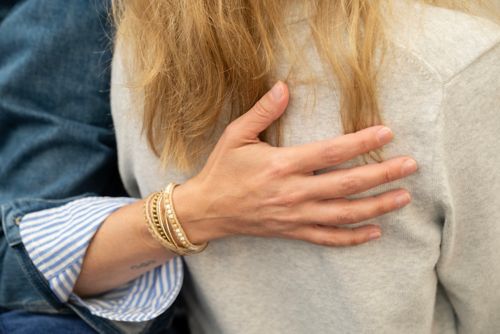 Woman comforting other woman with hand on her back