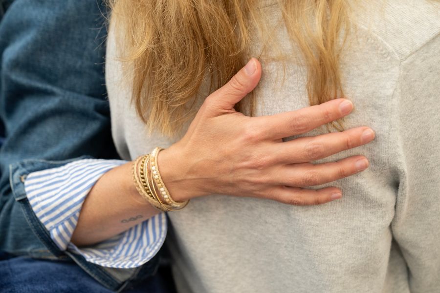 A hand placed on a woman's back