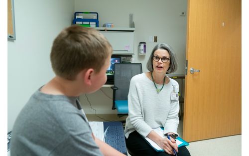 Female doctor talking with male child patient