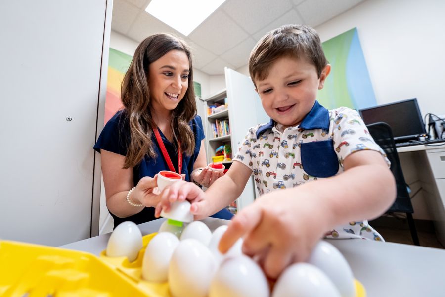 A speech therapist playing with child cancer patient