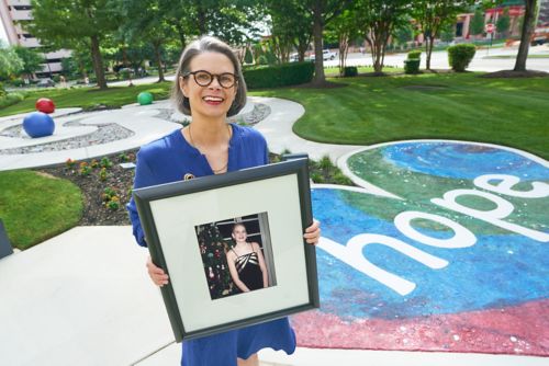 Emily Browne holding a picture of herself when she was a patient at St. Jude