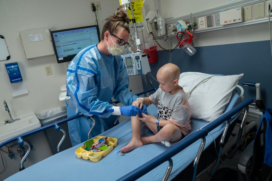 Nurse helps female patient in hospital room setting