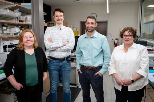 group of people standing in a row in a lab