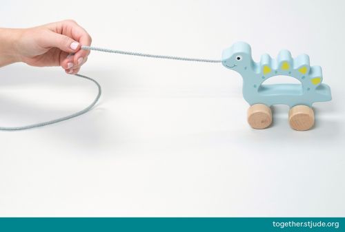 Person pulling push/pull toy by its string