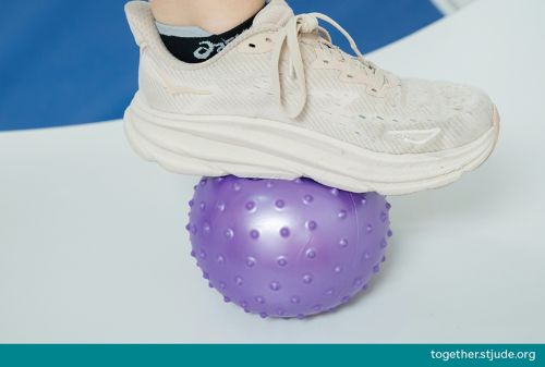 Person's foot on top of ball