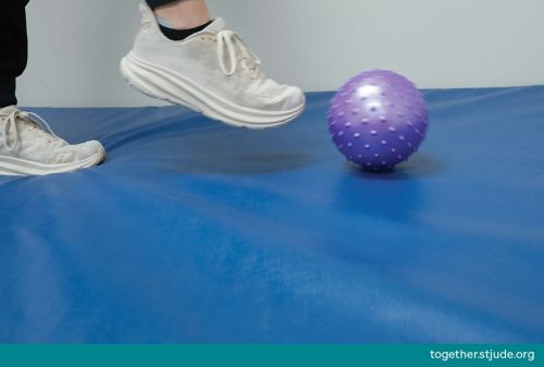 Person kicking purple ball 