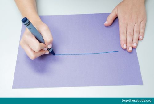 Person drawing horizontal line on construction paper