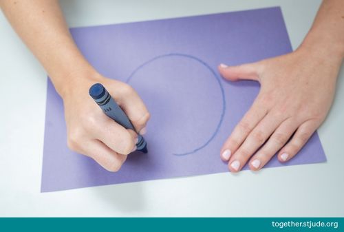 Person drawing circle on construction paper