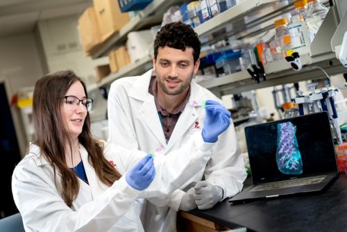 man and woman in lab coats examining something