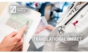 a pair of hands holding a piece of paper with dots on it, near a person wearing a medical coat with a St. Jude logo