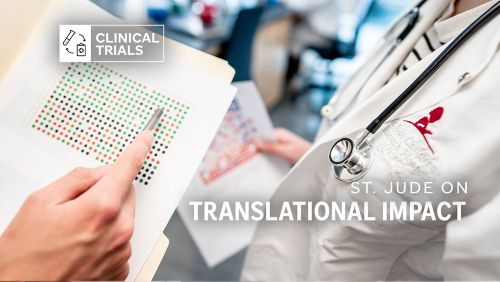 A pair of hands looking at a paper with dots on it. A person in a medical coat w/a St. Jude logo is next to them.