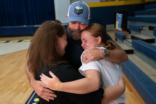 Annabelle Guy takes a break during cheer practice to visit with her mom and dad.
