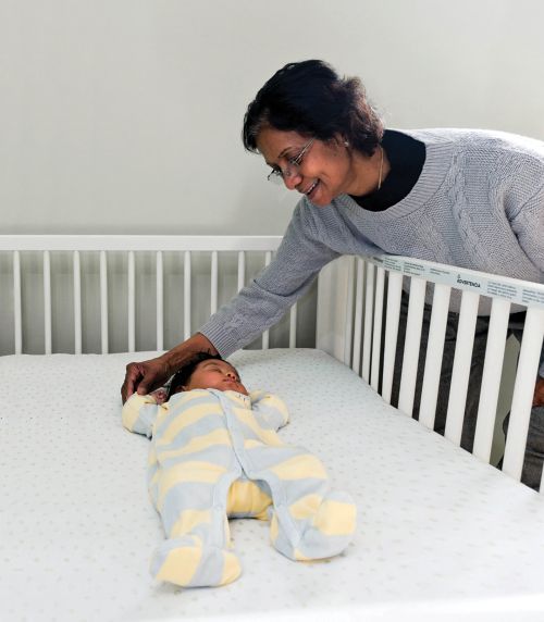 Baby sleeping in a crib with rails