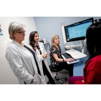 three doctors and a patient in an exam room