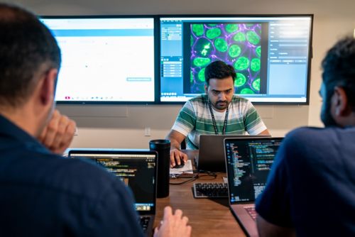 People at a table working at computers 