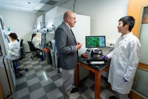 Alejandro Gutierrez talking to a lab member