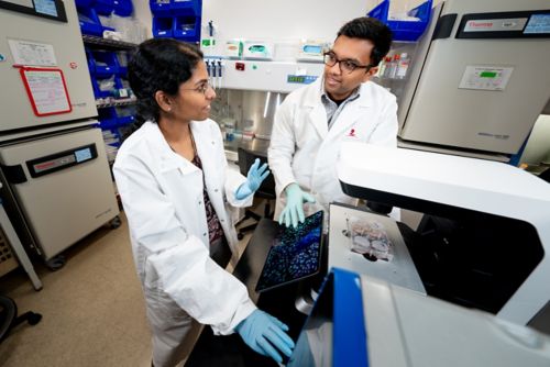 man and woman talking in a lab