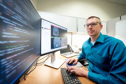 Member of Asim Bag Lab team working at a computer with multiple screens in front of him. 