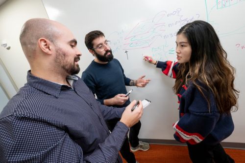 Three people at a white board