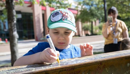 male child signing metal beam for St. Jude new building