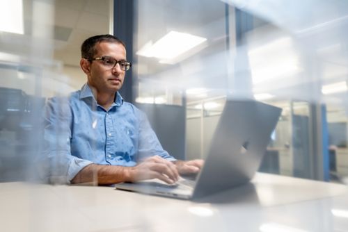 Yadav Sapkota, PhD, sitting at computer in office