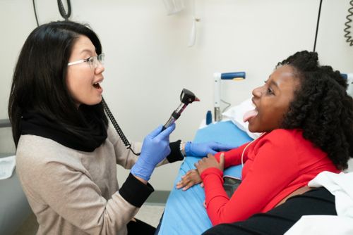 Amy Ly, MD, with a female patient in clinical setting