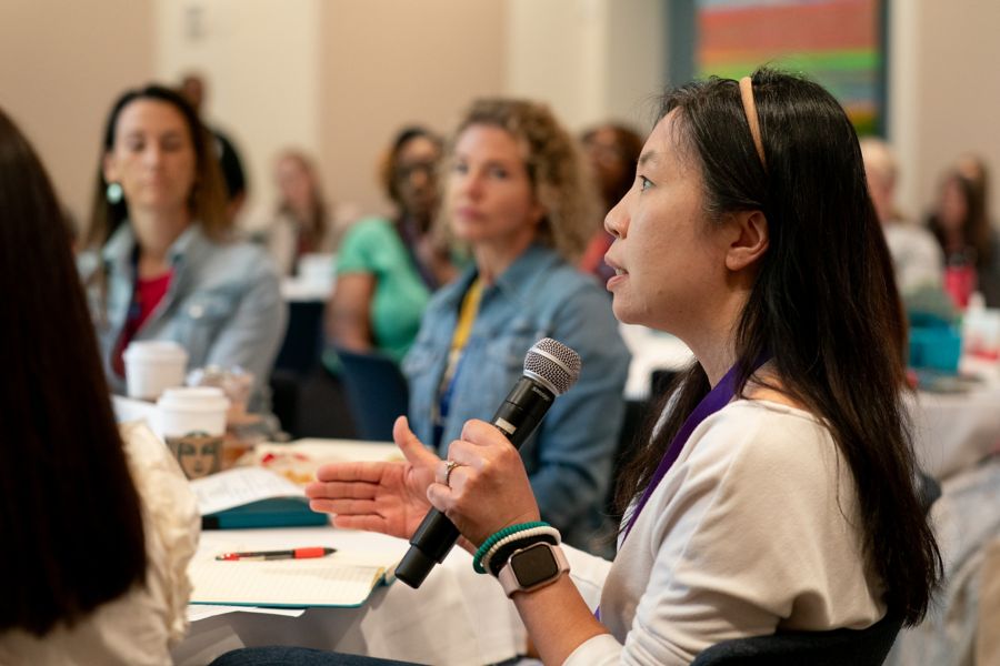 Woman speaking into microphone at retreat