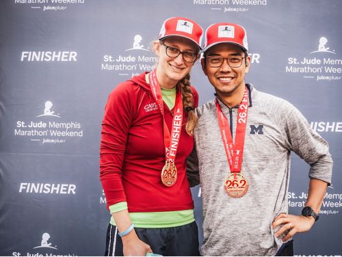 Nicole Michmerhuizen, PhD, and her husband, Clarence Pascual wearing finisher medals at the St. Jude Marathon
