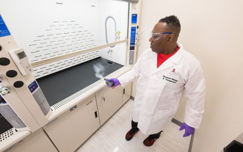 Man in white coat using lab equipment