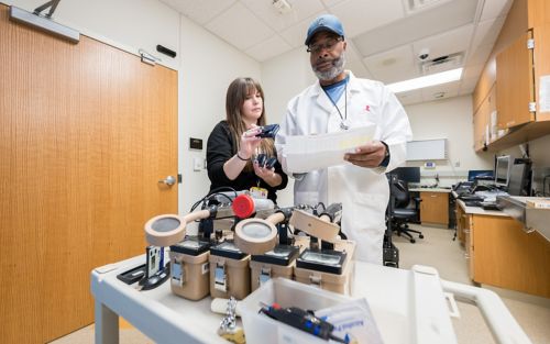 Man in white coat using lab equipment