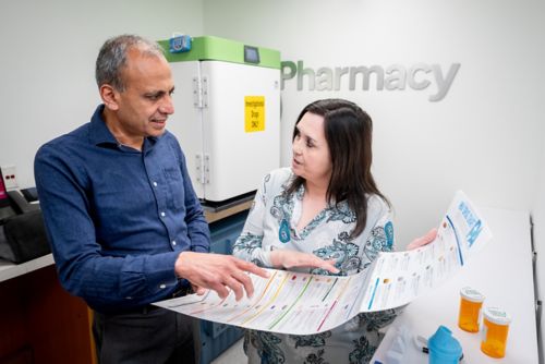 Two people looking at a long piece of paper