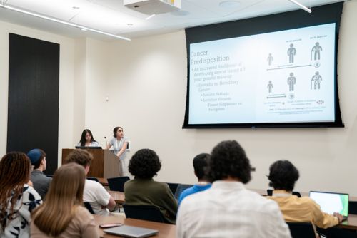 Two high school girls presenting research to a group