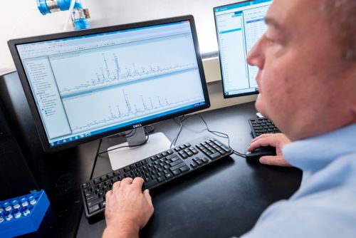 A man working at a bank of computer screens