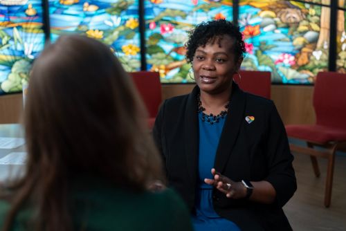 Tekeima Townsend-Billups speaking to a woman at the chapel