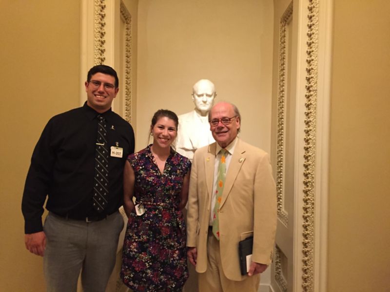 Three people standing in hallway