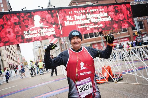 James Eversull running in St. Jude marathon with St. Jude banner in background