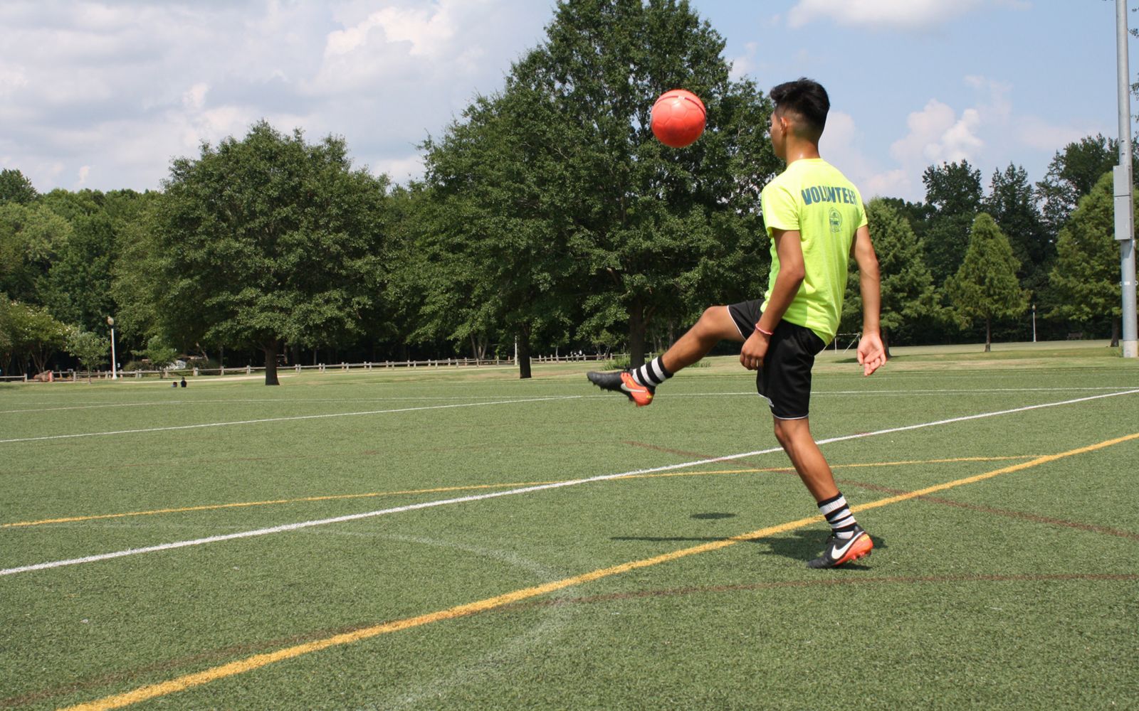 A boy kicks a soccer ball on a soccer field