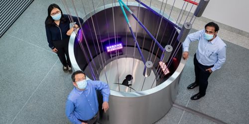 Image of people standing around lab equipment