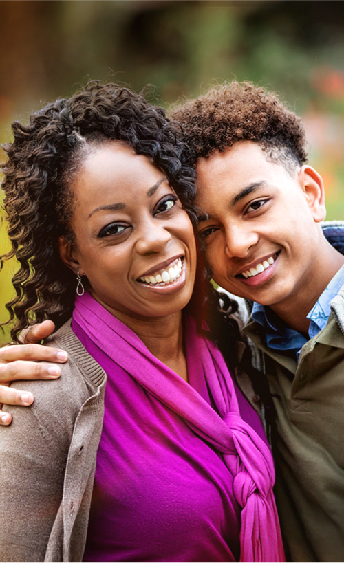 Adult and young adult embracing and smiling