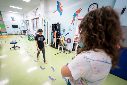 Boy walking in PT clinic