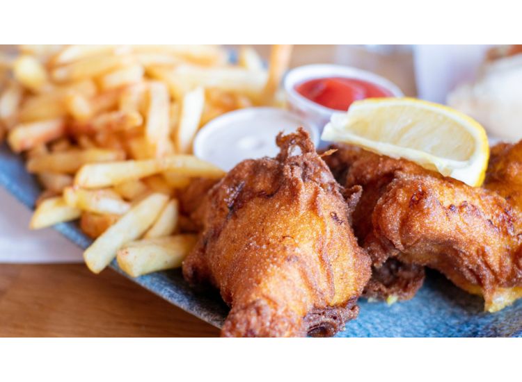 Fried fish on a plate with french fries.