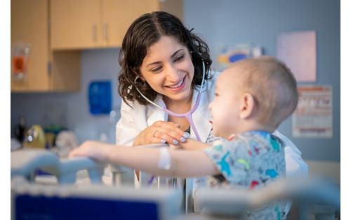 Dr. Asya Agulnik with childhood cancer patient, indoors